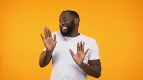 Hombre Negro Feliz Relajado Bailando Sobre Fondo Amarillo Mirando Cámara — Vídeos de Stock