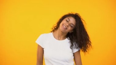 Kıvırcık saç sallayarak ve dans, kamera mutluluk üzerinde gülümseyen samimi biracial kız