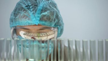 Test tüpüne, organik ürünler yeşil sıvı dökme laboratuvar asistanı