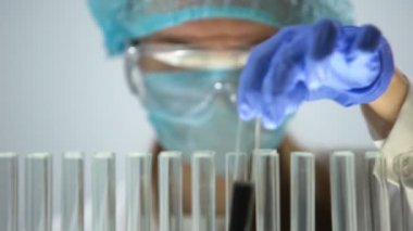 Test tüpleri siyah bir madde ile işaretleme, kimyasal reaksiyon kontrol etme bilim adamı