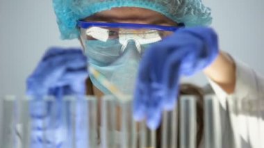 Laboratuar işçisi turnusol kağıdı, idrar testi ile sarı sıvı pH seviyesi ölçümü