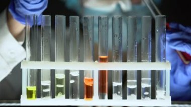 Test tüpleri kırmızı sıvı dökme ve reaksiyon, sahte ilaç kontrol kimyager