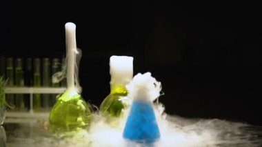 Çok renkli maddeler köpüren ve karanlıkta, duman yayan şişeler içinde test