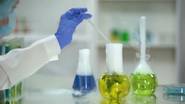生物化学家从烧瓶中提取黄色有机物质样品 植物提取 — 图库视频影像