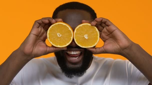 Playful African Male Holding Orange Slices Front Eyes Vitamin Nutrition — Stock Video