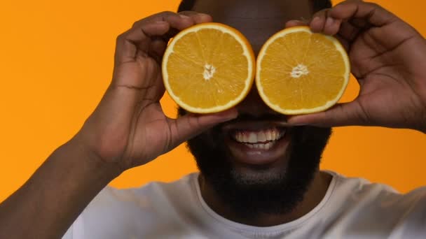 Homem Africano Sorridente Mostrando Suculentas Metades Laranja Frente Para Olhos — Vídeo de Stock