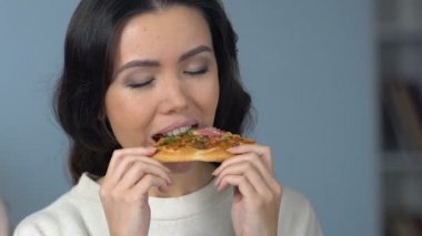Sarışın kız sulu elma yeme Asya arkadaşı aksine önemsiz pizza için tercih