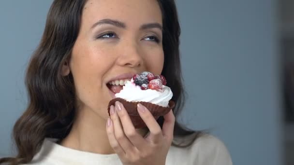 亚洲妇女享受美味的甜纸杯蛋糕与奶油和水果的味道 — 图库视频影像