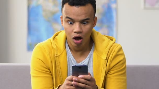 惊讶的黑人高中生浏览智能手机 现代约会社交应用程序 — 图库视频影像