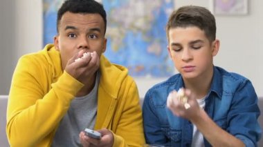 İki yarım yamalak genç çocukların tv, patlamış mısır, yeme film izlerken eğlence Anasayfa