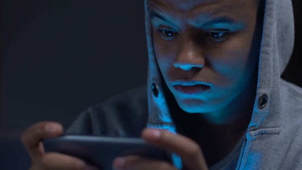 Adolescent noir jouant jeu smartphone dans l'obscurité, dépendance gadget malsain — Video