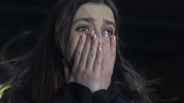 Шокированная женщина плачет стоя под мостом, жертва маньяка, насилие, крупный план — стоковое видео