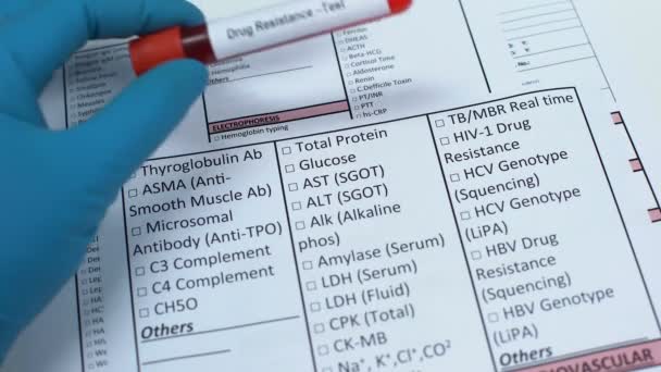 Drug resistance, doctor checking name in lab blank, showing blood sample in tube — Stock Video