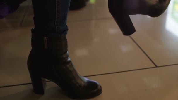 Mujer con botas de tobillo sentada en la sala de espera de cola, zapatos cómodos — Vídeos de Stock