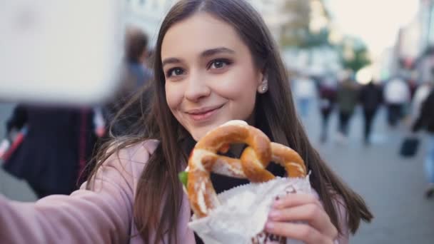 Beautiful girl making video about traditional German pretzel, culinary blog — Stock Video