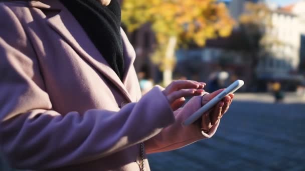 Mujer en abrigo llamando a taxi a través de la aplicación en línea en el teléfono celular, utilizando la navegación GPS — Vídeo de stock