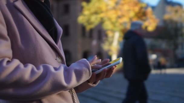 Chica en abrigo de congelación en la calle, llamando a taxi, utilizando la aplicación de GPS en línea para encontrar café — Vídeo de stock