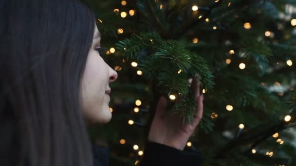 Schöne Frau träumt in der Nähe von Weihnachtsbaum, Wünsche in den Winterferien — Stockvideo