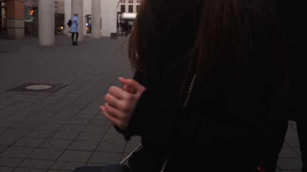 Menina congelando enquanto espera amigos ao ar livre, mãos frias, problema de pressão arterial — Vídeo de Stock