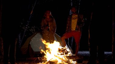 Şenlik ateşi bira şişeleri ile duruyorlar, iyi vakit geçiriyor kampçılar gülümseyen