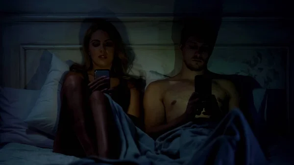 Ζευγάρι Κάθεται Στο Κρεβάτι Κουβεντιάζοντας Για Smartphones Δεν Μιλάμε Gadget — Φωτογραφία Αρχείου