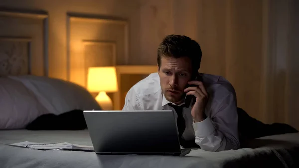 Thoughtful Male Typing Laptop Talking Phone Preparing Report Deadline — Stock Photo, Image