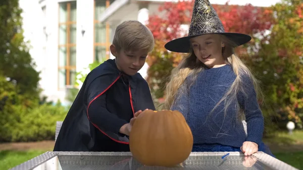 Junge Und Mädchen Maskenkostümen Zeichnen Gruseliges Gesicht Auf Kürbis Halloween — Stockfoto