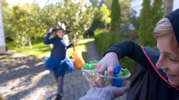 Fröhliche Jungen Und Mädchen Kostümen Die Bonbons Vom Teller Nehmen — Stockfoto