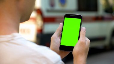 Test sonuçları, ambulansın arka plan, closeup okumak için cep telefonu kullanan hasta