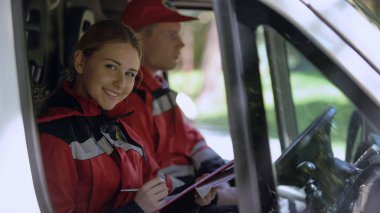 Ambulansta, rapor yazma Doktor gülümseyerek kameraya, acil tıp reform