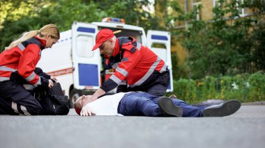 Doktorlar bilinçsiz adam, kalp krizi veya trafik kazası için acil bakım sağlamak