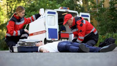 Ambulans hizmeti personel bakım hasta yolda, intravenöz ekipman koymak için
