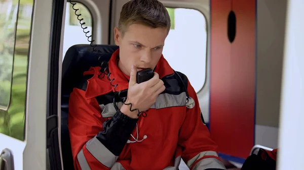 ラジオ 救急車 オンコール ドライブへの準備に座って話している男性救急救命士 — ストック写真