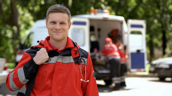 Médico Masculino Sonriendo Cámara Equipo Ambulancia Trabajando Borroso Fondo —  Fotos de Stock