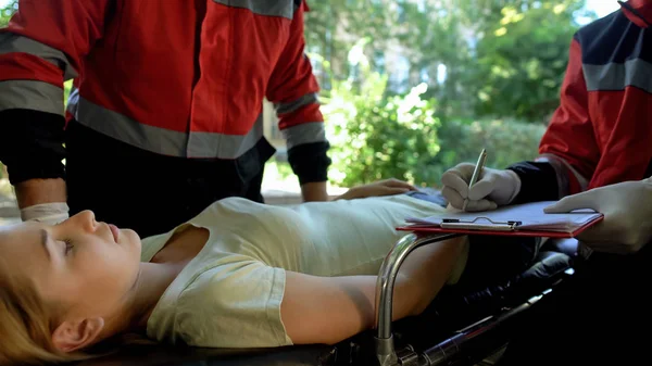 ストレッチャー 同僚を記録 救助隊の救急救命士試験女性 — ストック写真