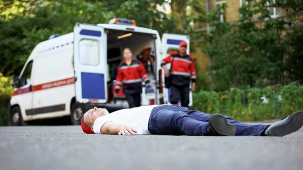 Nieprzytomnego Człowieka Leżącego Drodze Sanitariuszy Ofiarą Wypadku Samochodowym — Zdjęcie stockowe