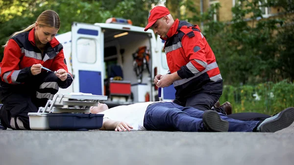 Sanitariuszy Pomagając Nieprzytomnego Człowieka Drodze Dokonywanie Wtrysku Insuliną — Zdjęcie stockowe