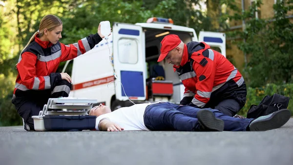 Personal Del Servicio Ambulancia Atiende Paciente Carretera Colocando Equipo Intravenoso — Foto de Stock