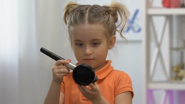 Забавная маленькая девочка, наносила мамину пудру на лицо и смотрела в зеркало, играя — стоковое видео
