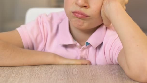 Расстроенный мальчик смотрит на брокколи с отвращением, отказ есть, вегетарианский образ жизни — стоковое видео