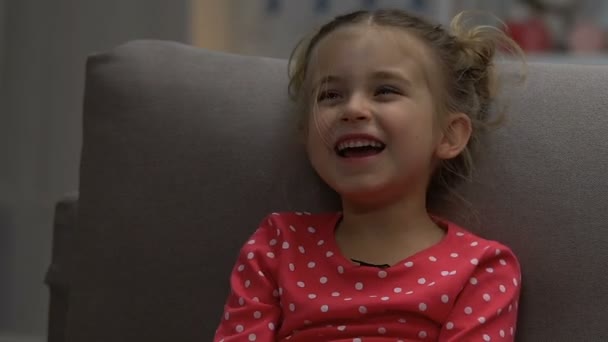 Niedliches kleines Mädchen, das nachts allein Comedy-Show guckt und lacht, aus nächster Nähe — Stockvideo