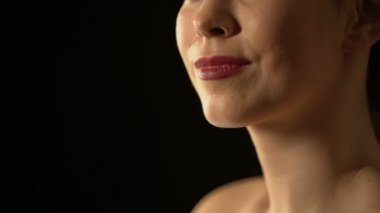 Gülümseyen kadın siyah eldiven kamera siyah arka plan karşı hava öpücük gönderme