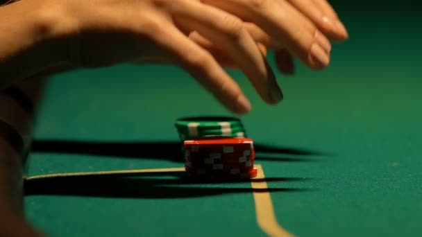 Mujer poniendo las últimas fichas de póquer en la mesa de juego, haciendo apuestas all-in, primer plano — Vídeo de stock