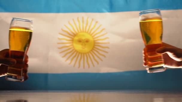 Fans rammelende bierglazen, Argentijnse vlag op de achtergrond, team sport ondersteuning — Stockvideo