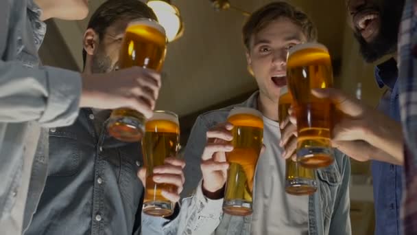 Gelukkig groep vrienden rammelende bierglazen, verjaardag partij in pub — Stockvideo