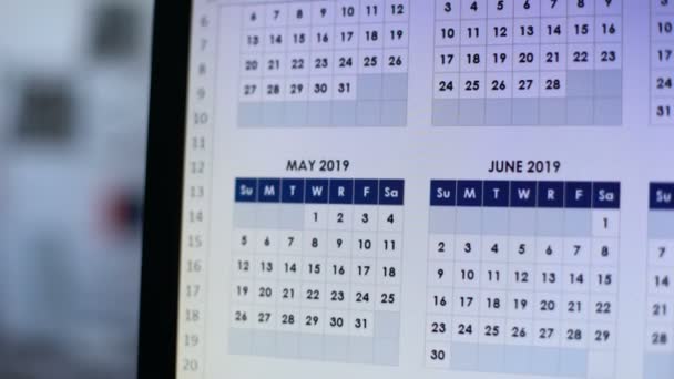 Человек просматривает календарь на компьютере, строит планы на будущий год — стоковое видео
