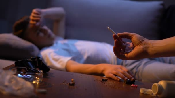 Tiener nemen onkruid gezamenlijk uit het aanbieden van hand en verlichting it, schadelijke verslaving — Stockvideo