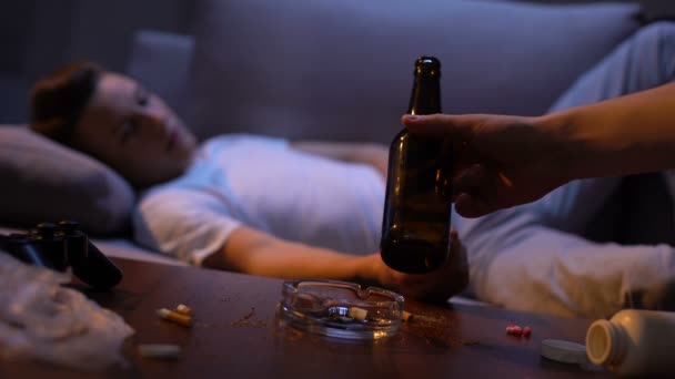 Mano que ofrece adicto joven botella de cerveza masculina, abuso de alcohol perjudicial — Vídeo de stock