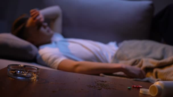 Drug addicted student sleeping, cigarette smouldering in ashtray, fire risk — Stock Video