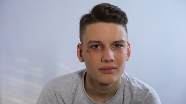 Nešťastný teenager s rány na tváři se jí dotknete a při pohledu na fotoaparát, boj — Stock video